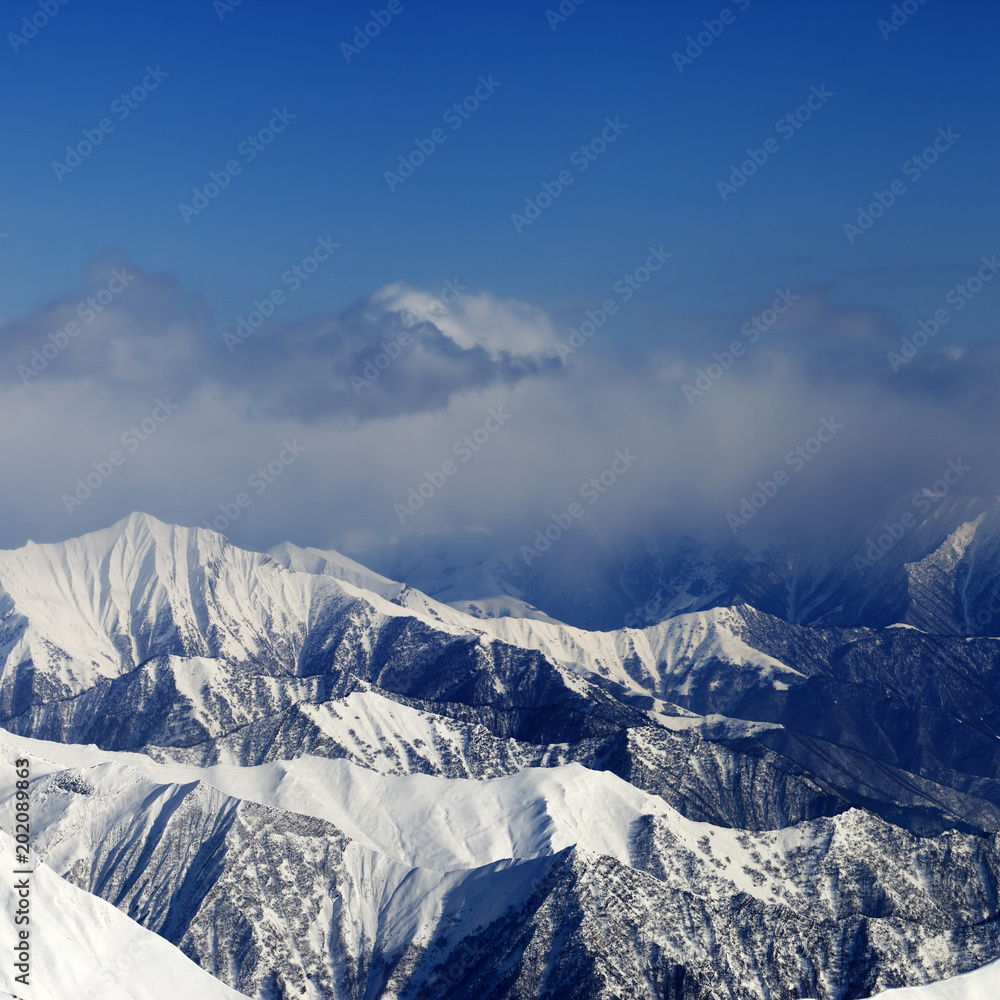 Fototapeta premium Sunlight snowy mountains in fog