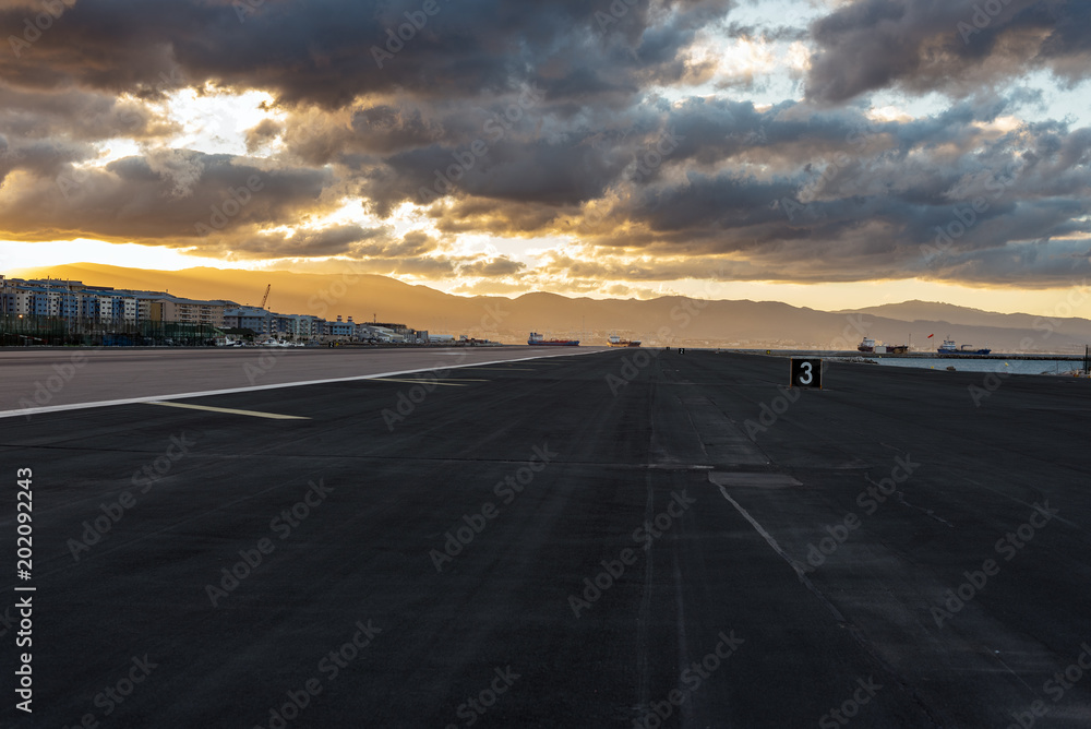Sunset with stormy clouds over airport runway in Gibraltar