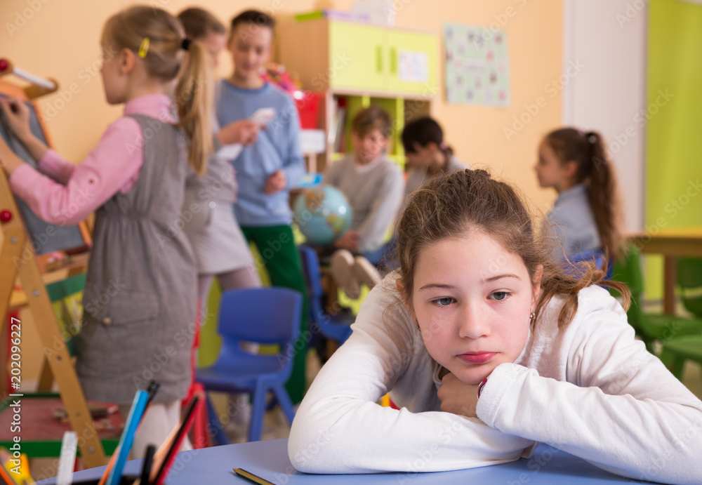 Obraz premium Sad bored schoolgirl in classroom at break