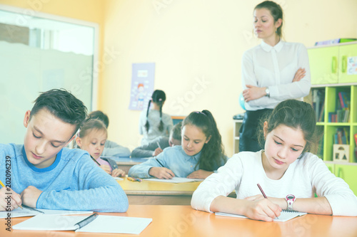 School kids studying in classroom with teacher
