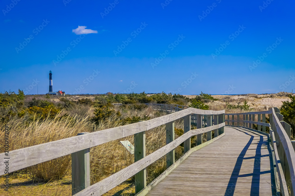 Outdoor view of long wooden bridge in a beautiful sunny day with blue sky, at Long island