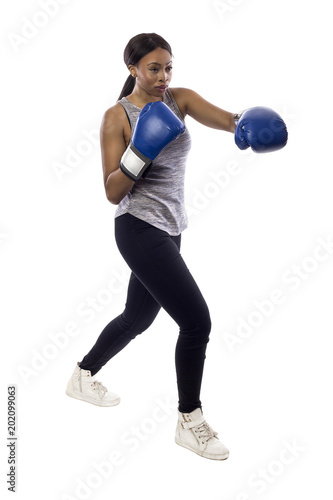 Black female isolated on a white background wearing boxing gloves working out with box aerobics cardio.  She is posing with punches and depicts fitness or self-defense and martial arts. photo