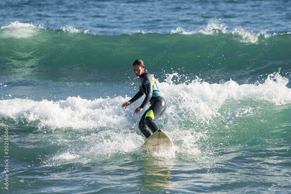 Chica surfista surcando una ola