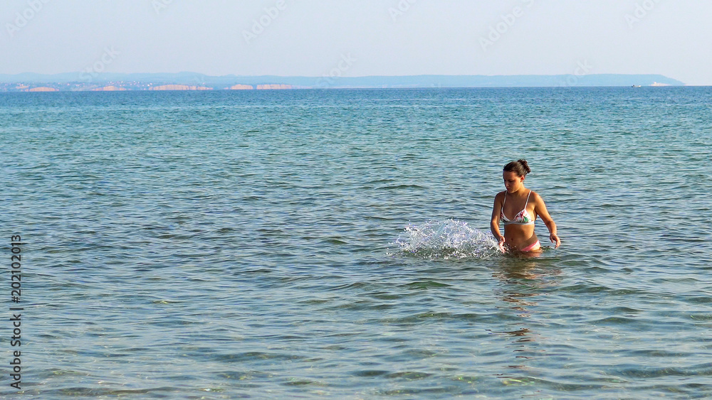 Beautiful teen walking out of sea water