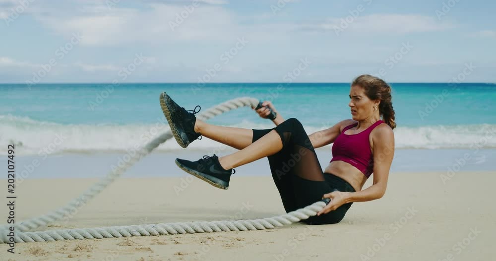 Athletic woman exercising with battle ropes Athletic woman exercising with battle ropes