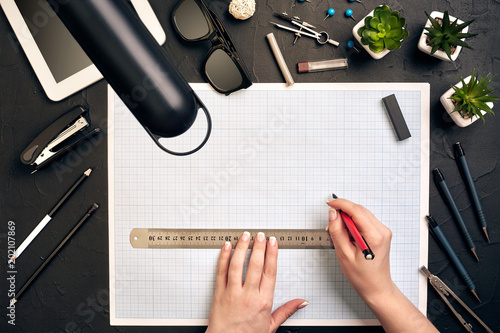 Fotografie Office desk background hand with pen writing construction project ideas concept, With tablet, drawing equipment and lamp
