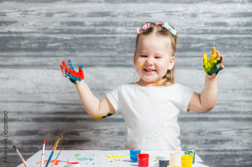 little girl draws. Hands of a girl in paint photo