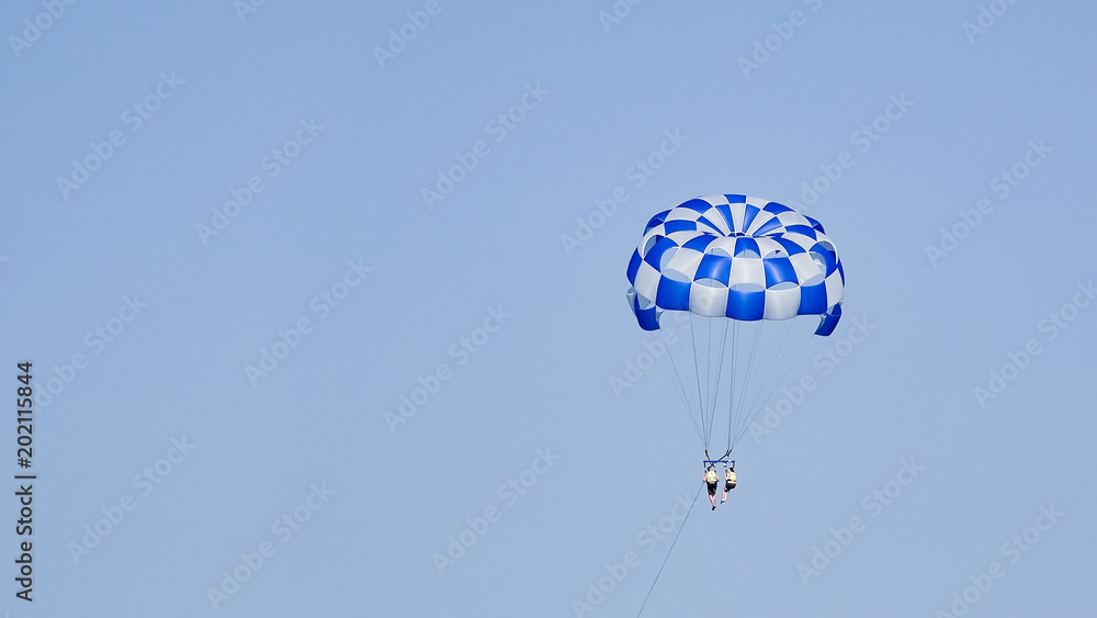 Two people on sea parasail parachute flight with blue sky copyspace Two people on sea parasail parachute flight with blue sky copyspace