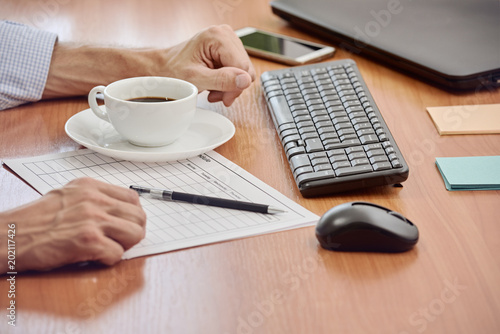 Closeup photo of businessman working with documents in modern office
