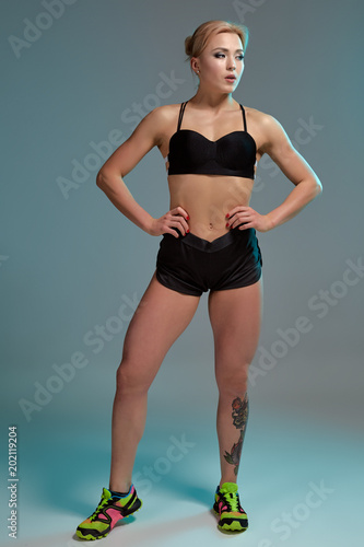 Fitness woman in black tank top and shorts, studio shot. photo