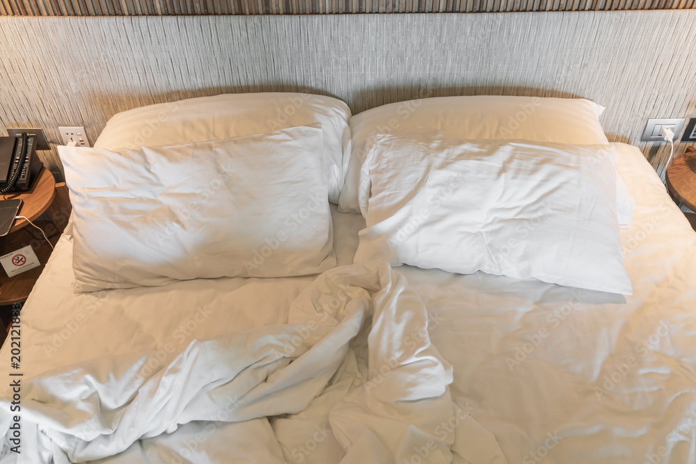 rumpled bed with white messy pillow rumpled bed with white messy pillow
