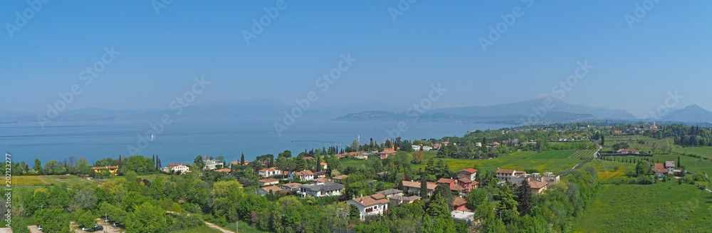 Aerial landscape of Lake Garda and its hills (blue water and green meadows contrast)