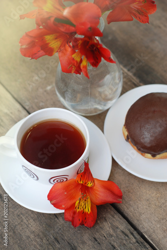 White Tea Cup Chocolate Donut Orange Red Flower Alstromeria Astromeria over Rustic Wooden Background. Copy space photo