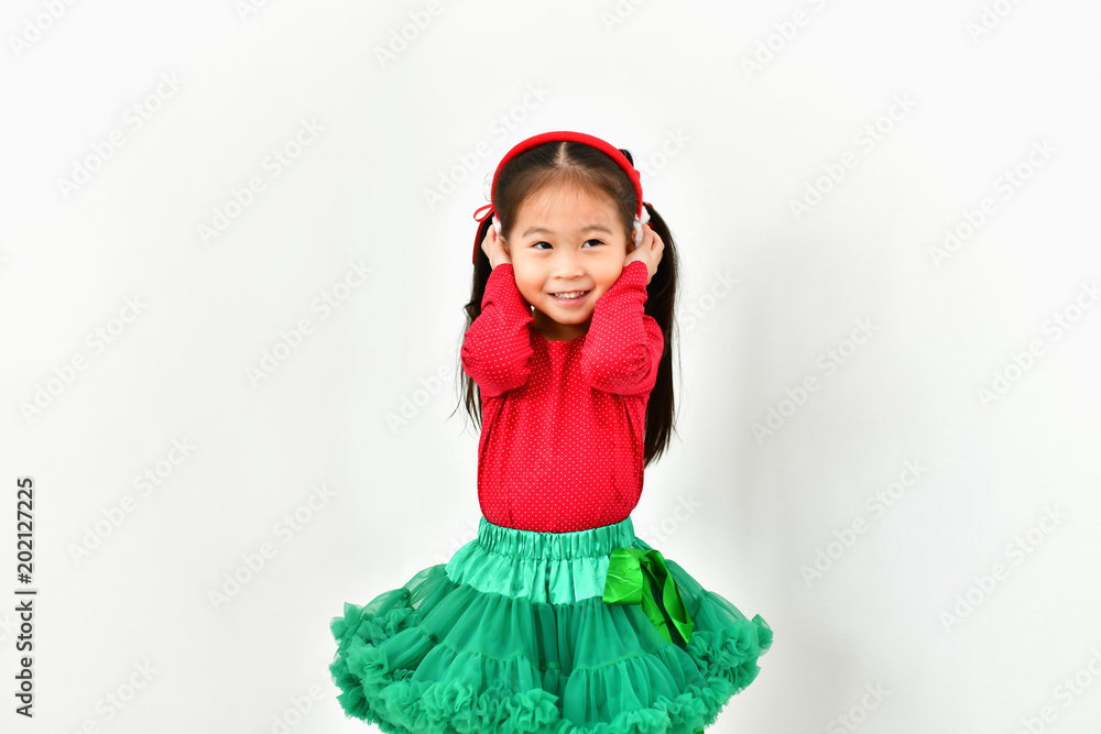 Little girl celebrates Christmas with red Santa dress.
