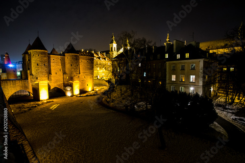 Night scene of Warsaw Barbacan fortress castle in winter is in the capital city of Poland. Old town is the historic center of Warsaw. architecture concept.