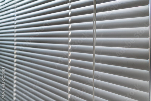 evening sunlight in the window through the closed blinds