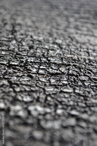 Dark surface cracked texture, soft blurry vertical background, close up detail