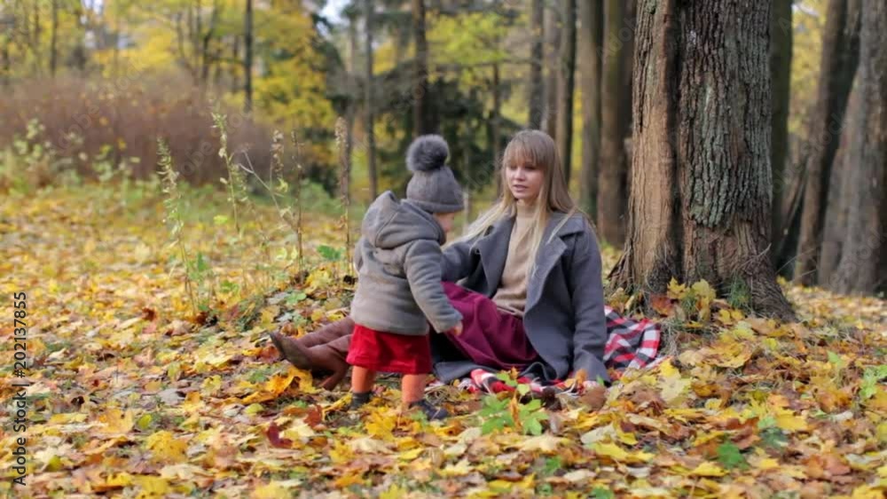 stylish woman with baby sitting in autumn park stylish woman with baby sitting in autumn park