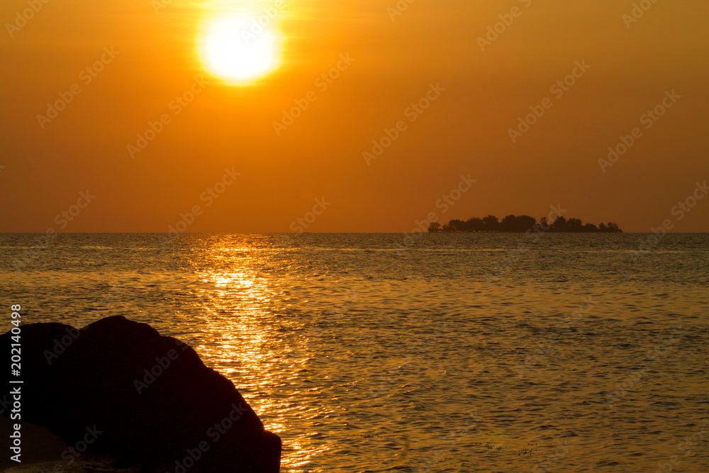 beautiful exotic sunset with orange sky and reflections on the sea