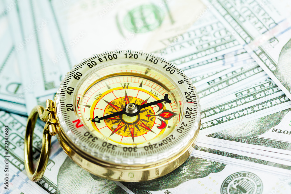 compass on pile of US money compass on pile of US money