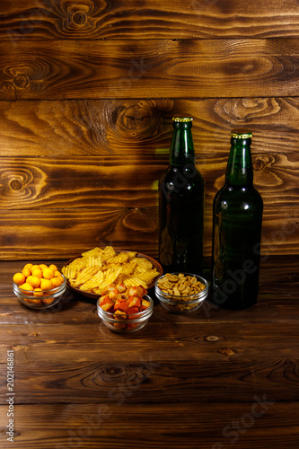 Fototapeta Naklejka Na Ścianę i Meble -  Bottles of beer and various snacks for beer on wooden table