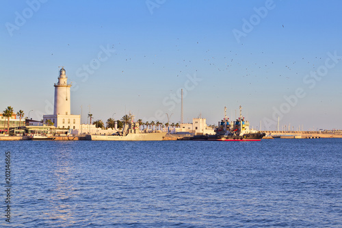 Lighthouse and boats in the harbor