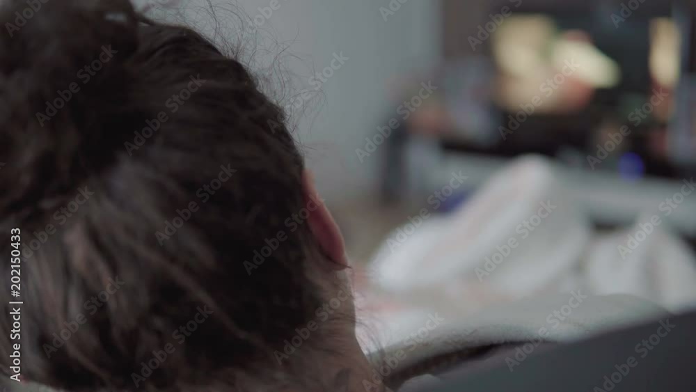 Sick child in bed watching TV rear view cinematic shot Sick child in bed watching TV rear view cinematic shot