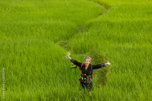 Hmong girl with traditional dress with basket of agricultural crops walking in the forest Happy Hmong girl are standing smiling at green nature at Sapa town Northern Vietnam.