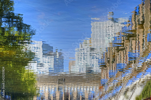 Reflection of severahl buildings and a tree in downtwon Rotterdam, The Netherlands, in the calm water of a canal