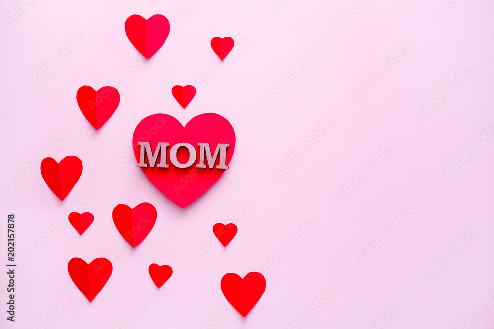 Beautiful composition with word MOM and paper hearts on color background. Happy Mother's Day