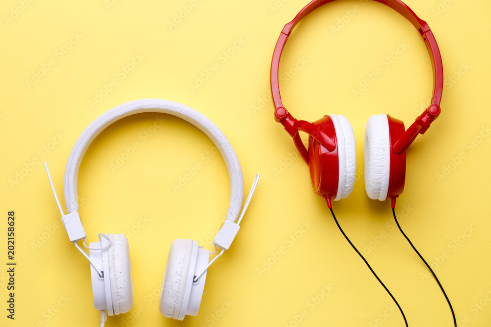 White and red headphones on empty yellow background White and red headphones on empty yellow background
