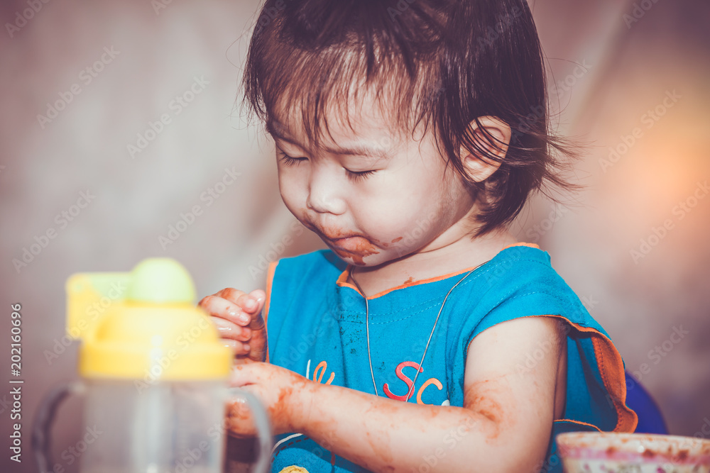 Child eating with a stained face. Do it yourself concept. Vintage tone. Child eating with a stained face. Do it yourself concept. Vintage tone.