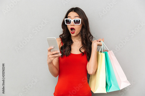 Shocked brunette woman in casual clothes and sunglasses
