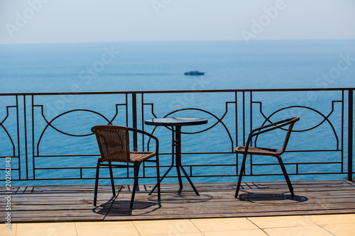 chairs and table on terassa by sea photo