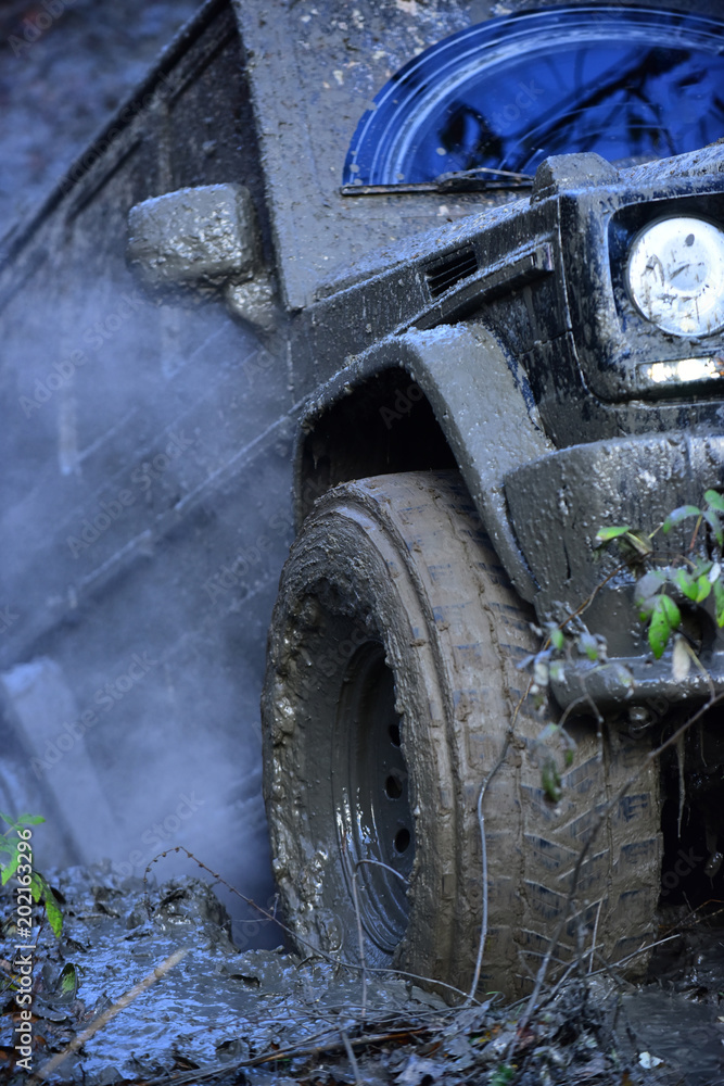 Fototapeta premium Part of SUV stuck in dirt, close up. Dirty tire