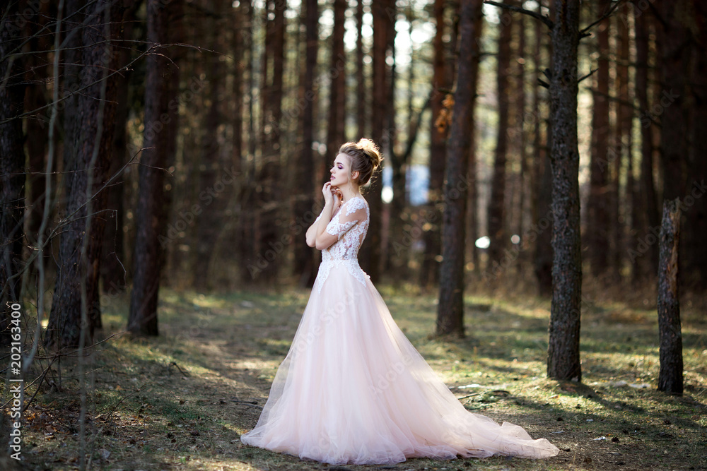 Portrait of beauty bride in white dress. bride is walking in the woods.