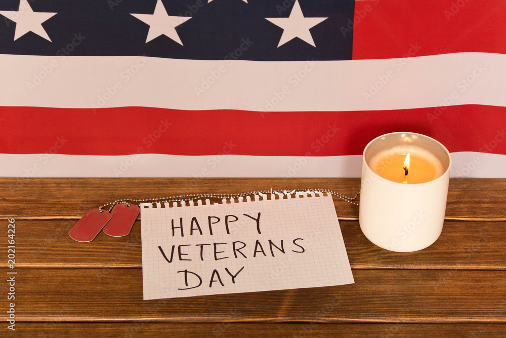 American flag and army tokens on veterans day . Memorial candle . On wooden background