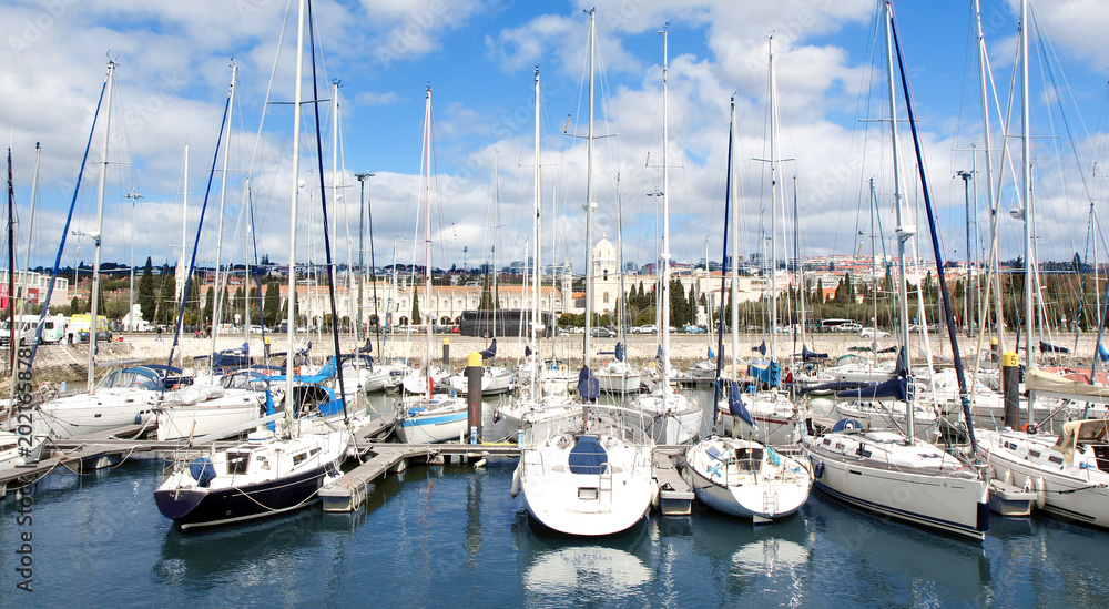 Panorama of the port with white sports yacht and an ancient town in the background 