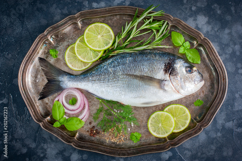 Fresh raw Dorado fish with fresh herbs, spices, lime, top view, horizontal