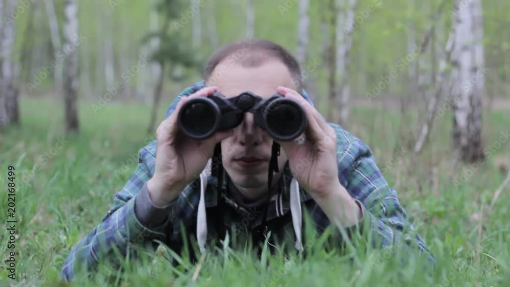 Close up of a man looking through binoculars, outdoors. Close up of a man looking through binoculars, outdoors.