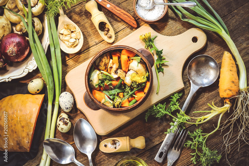 preparation of spring dish dandelions with pumpkin and mushrooms. ingredients and spices. wooden background.