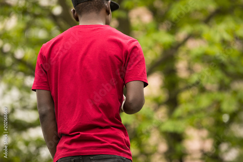 Trendy, cropped shot of black man in pink t-shirt, back view