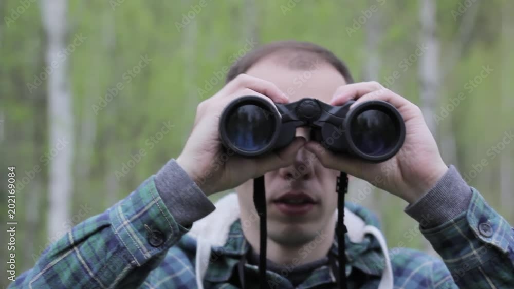 Tourist man looking through binoculars Tourist man looking through binoculars