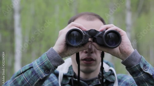 Tourist man looking through binoculars photo