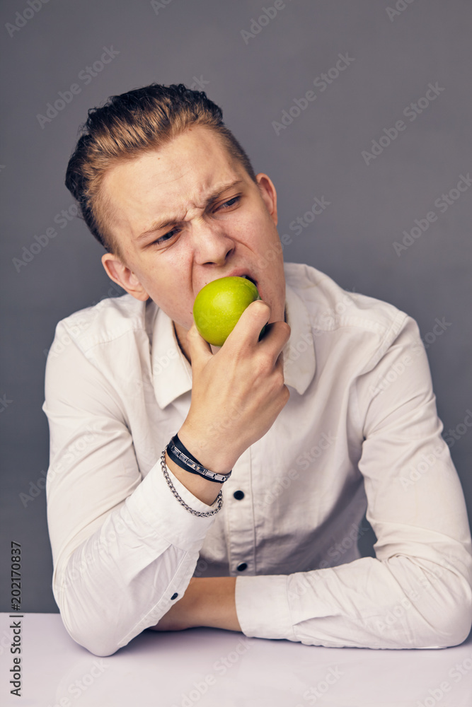 man eating apple, against dark background man eating apple, against dark background