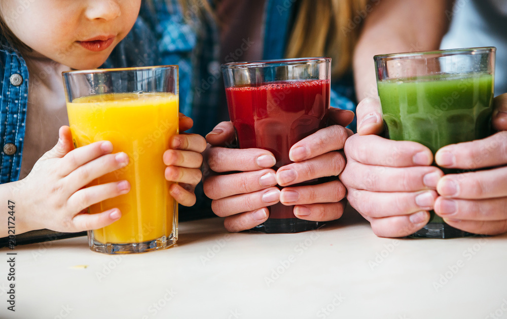 Family holding a glass of juice in hands. Family holding a glass of juice in hands.