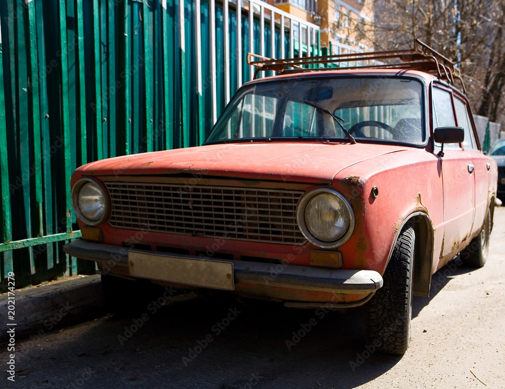 Parked old rusty red Soviet car. Parked old rusty red Soviet car.