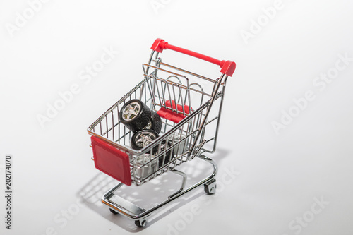 shopping cart in a shop full of tires and rims for a car. vehicle toy spare parts