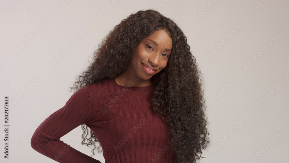 Beauty mixed race african american woman with hair blowed in air smiling at camera Beauty mixed race african american woman with hair blowed in air smiling at camera