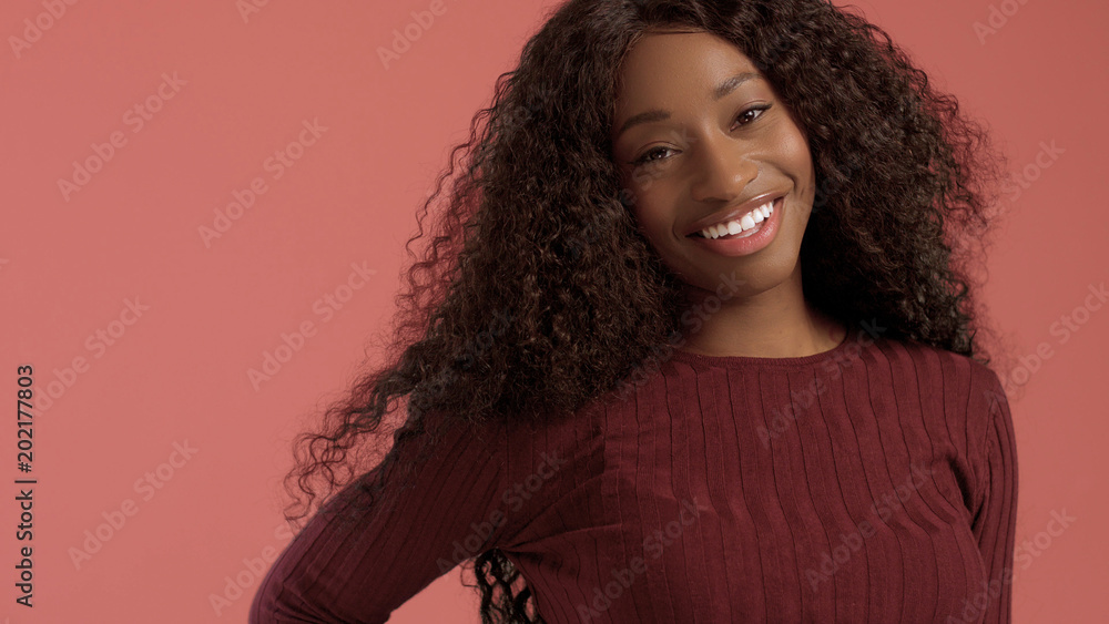 Beauty mixed race african american woman with hair blowed in air smiling at camera Beauty mixed race african american woman with hair blowed in air smiling at camera